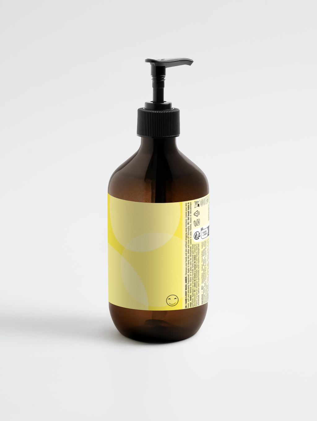 Amber glass bottle with pump and yellow label on a light gray background