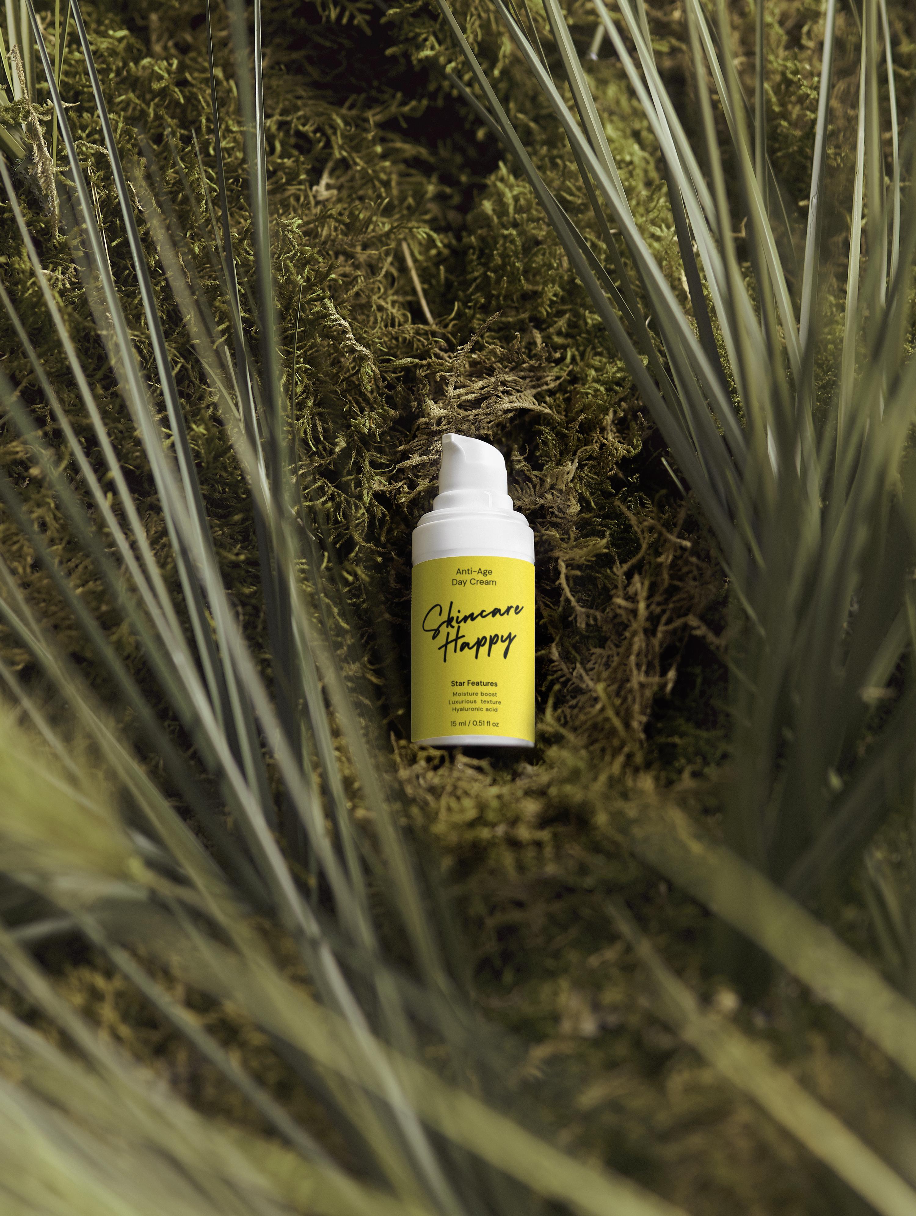Yellow spray bottle labeled 'Skincare Happy' on a natural background