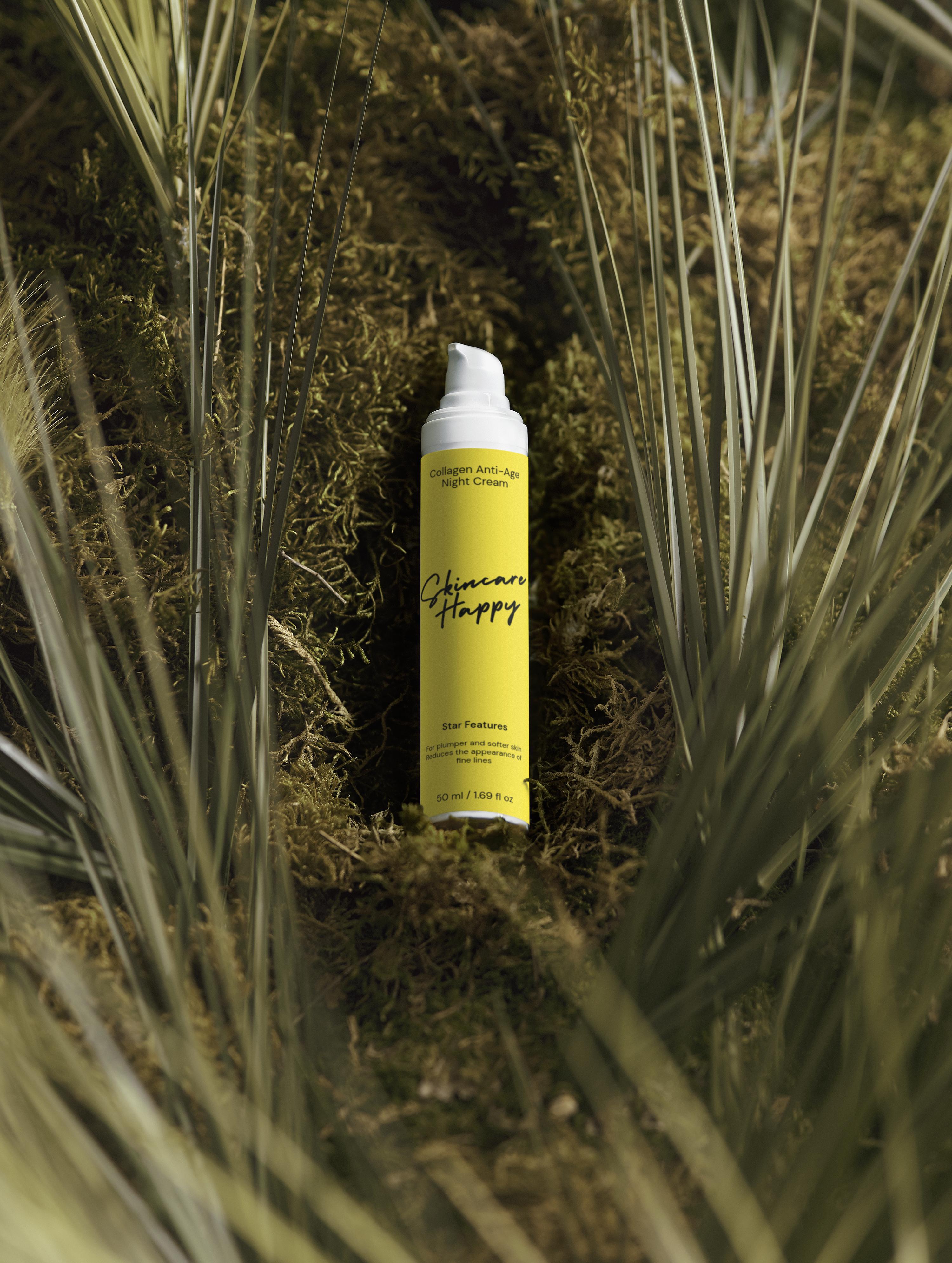 Yellow spray bottle with black text on a bed of green moss and grass